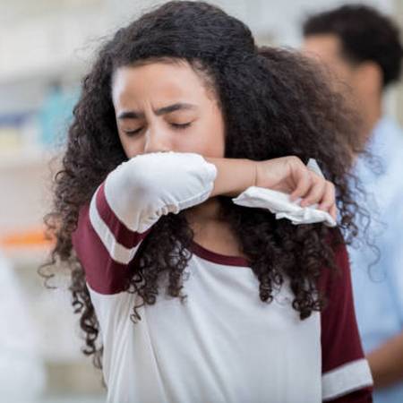 A girl covers cough with her elbow
